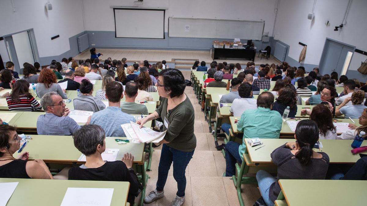 Vigilante repartiendo exámenes durante las oposiciones de la Generalitat.