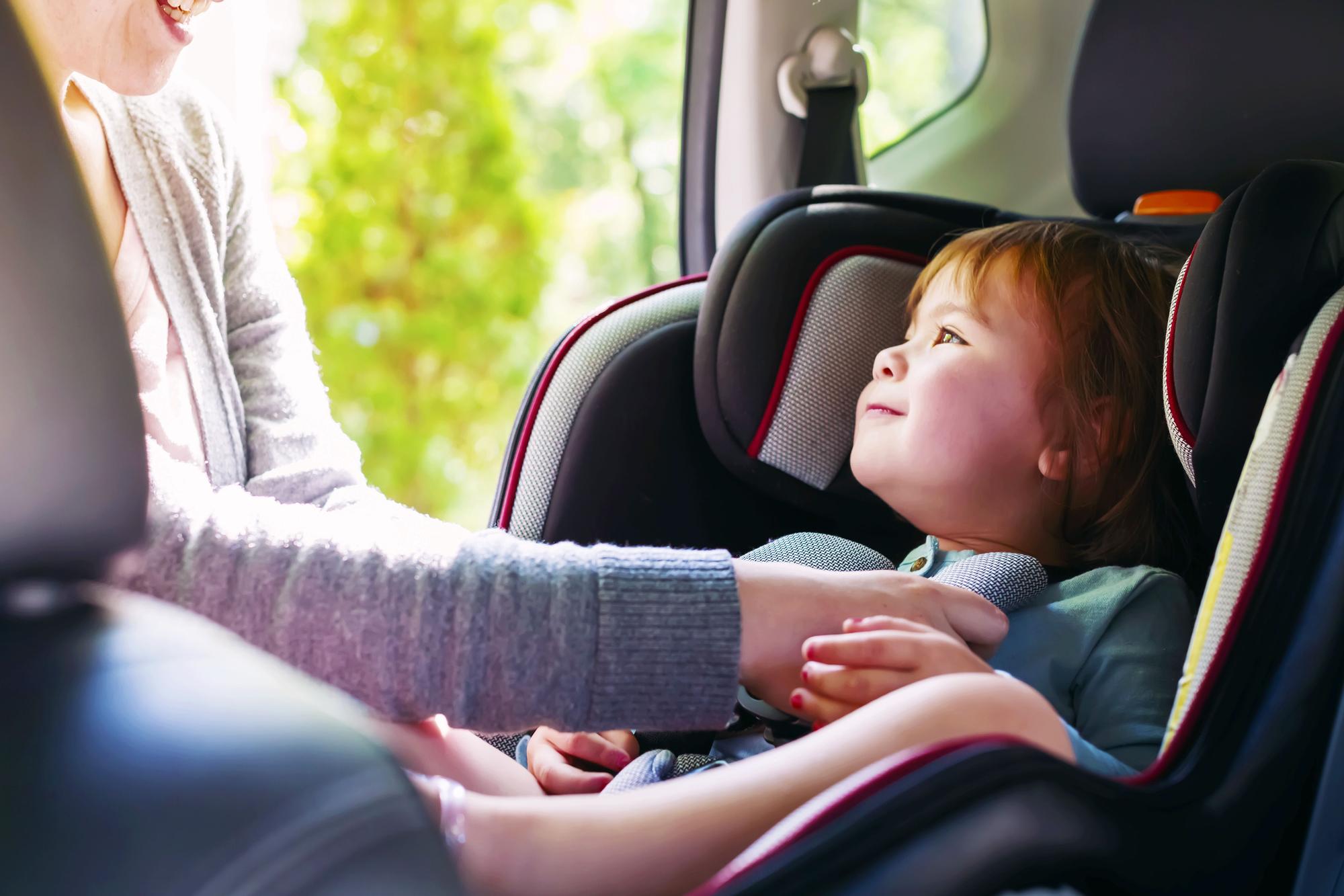 Niño abrochado en el asiento trasero de un coche