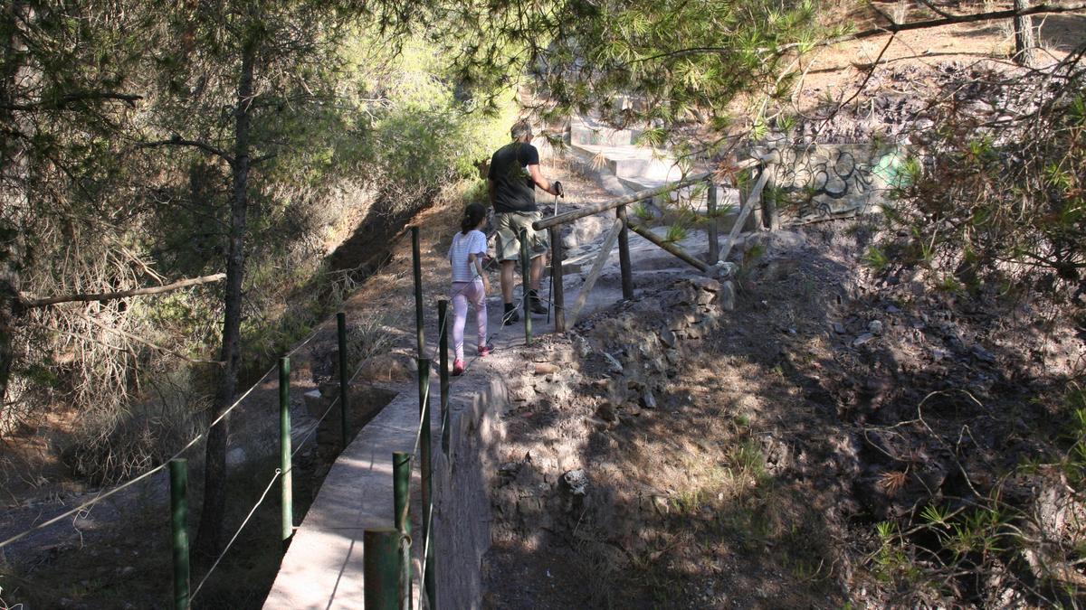 Dos senderistas cruzan uno de los puentes de una de las rutas más populares, la del Cejo de los Enamorados.