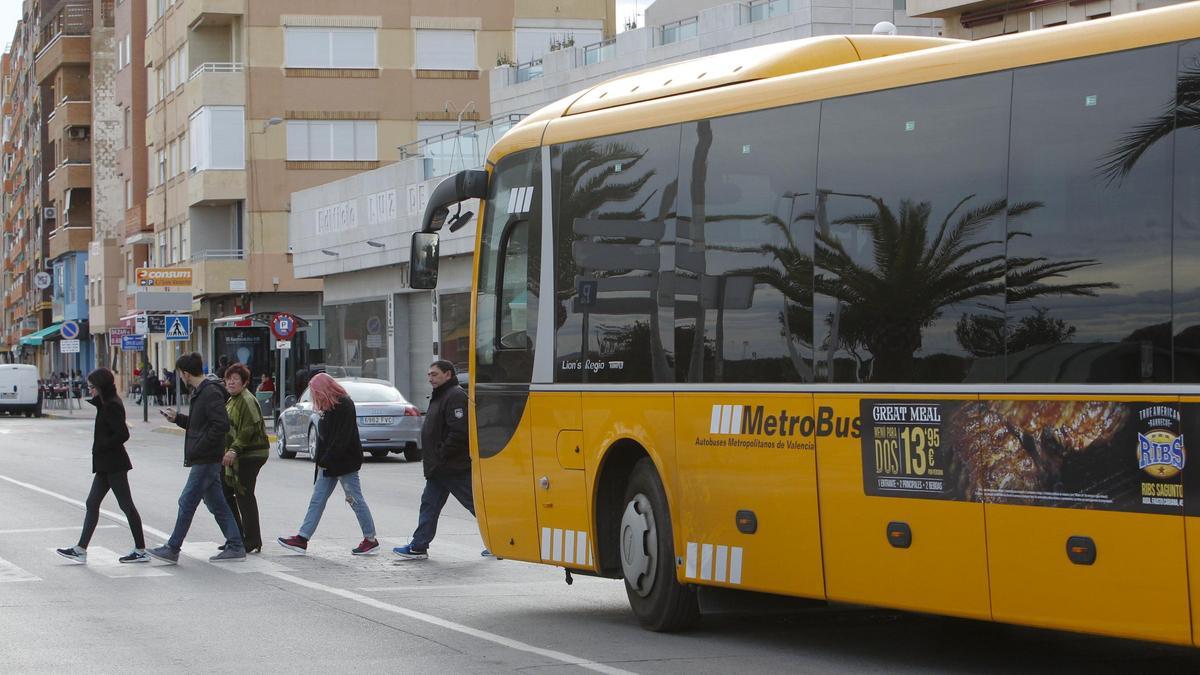 El autobús entre el Port de Sagunt y València espera el paso de unos peatones.