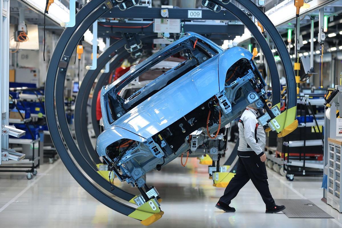 Los empleados trabajan en las carrocerías de los automóviles de lujo Porsche Taycan totalmente eléctricos en la línea de producción de la fábrica de Porsche AG en Stuttgart, Alemania.