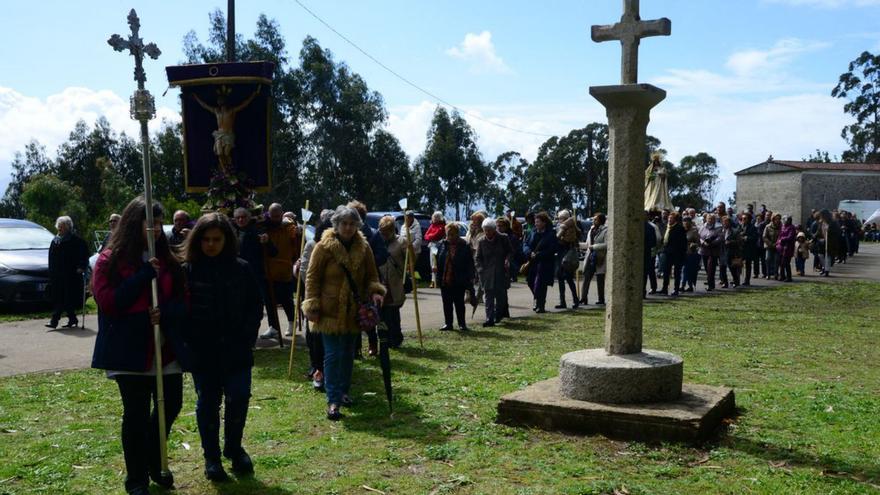 Los fieles, con las imágenes, ante el simbólico cruceiro de piedra.