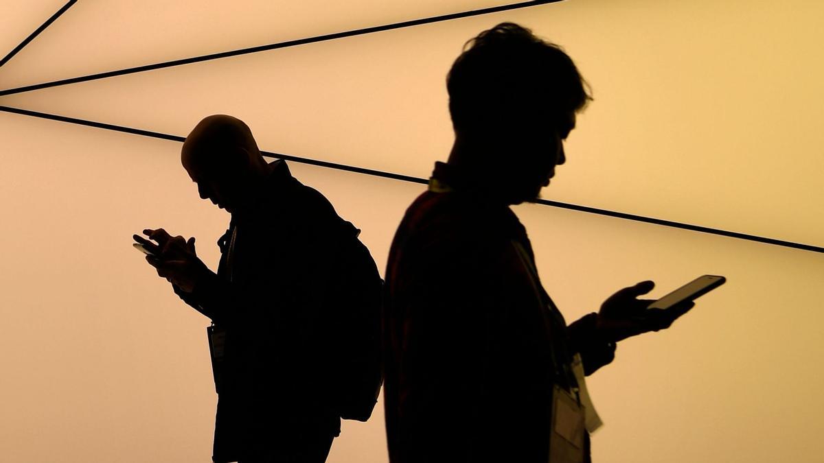 TOPSHOT - Visitors walk at the Mobile World Congress (MWC) in Barcelona on February 25, 2019. - Phone makers will focus on foldable screens and the introduction of blazing fast 5G wireless networks at the world's biggest mobile fair starting February 25 in Spain as they try to reverse a decline in sales of smartphones. (Photo by GABRIEL BOUYS / AFP)