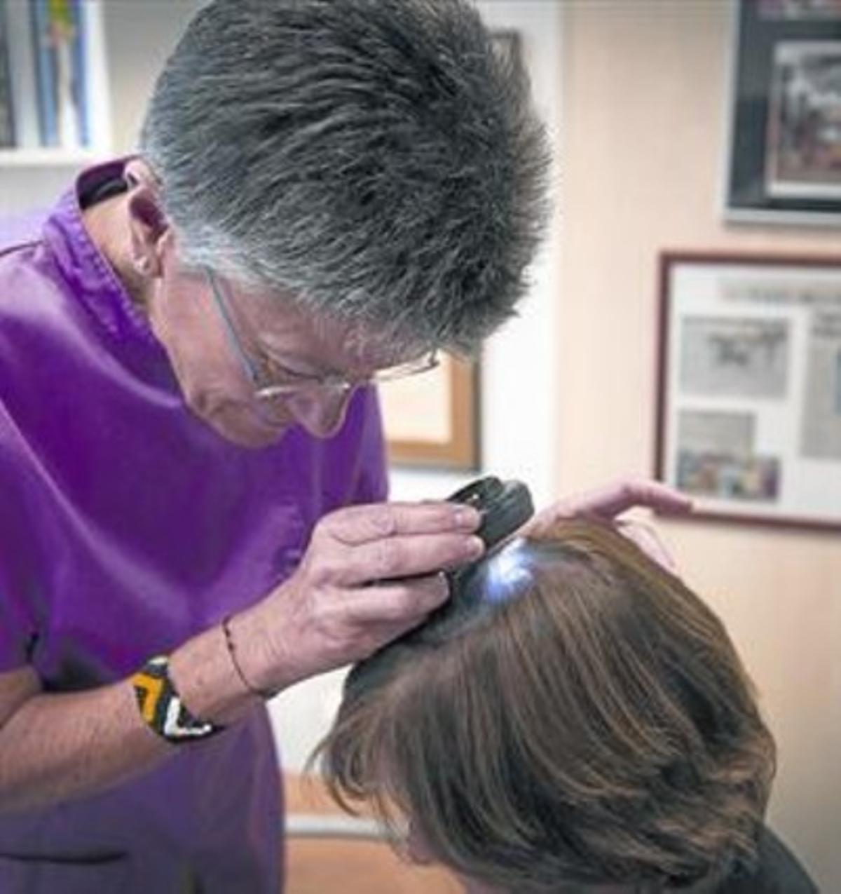 EN LA CONSULTA.La doctora Montse Pérez revisa el pelo de una paciente. EN LA CONSULTA.La doctora Montse Pérez revisa el pelo de una paciente.