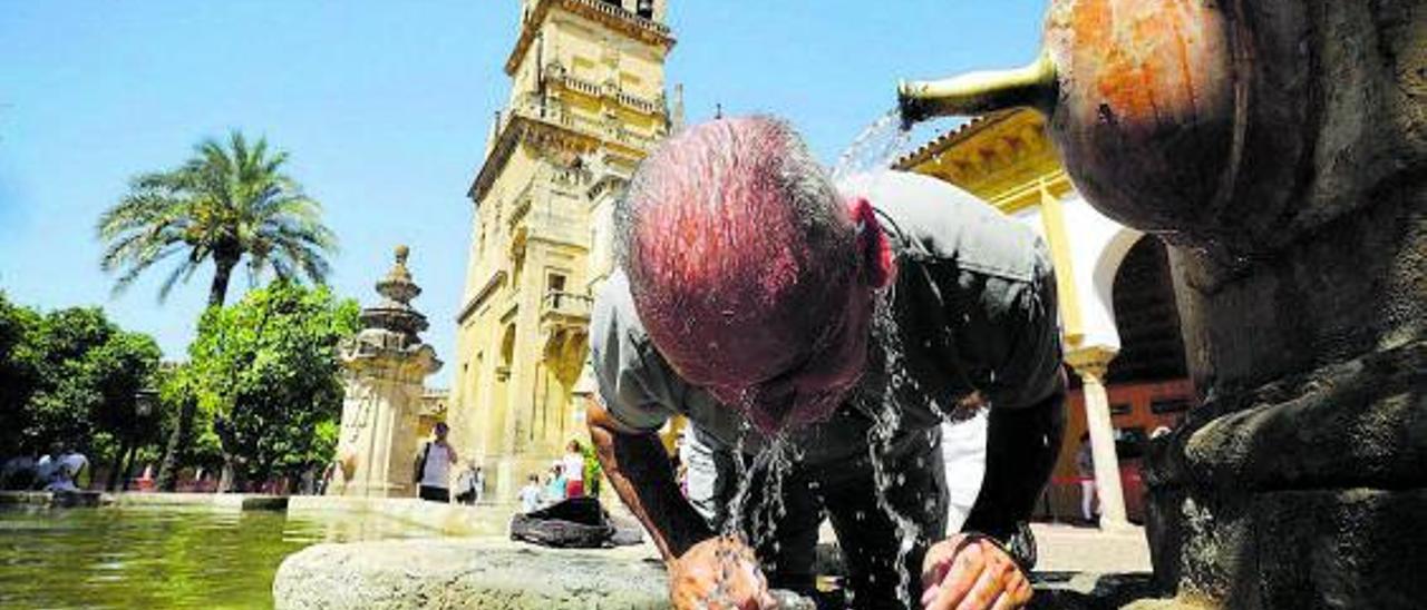 Un hombre se refresca en una fuente, ayer, en Córdoba. |  // EFE