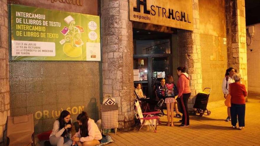 Familias, ayer por la noche, aguardando a las puertas del Conseyu de Mocedá para el intercambio de libros.