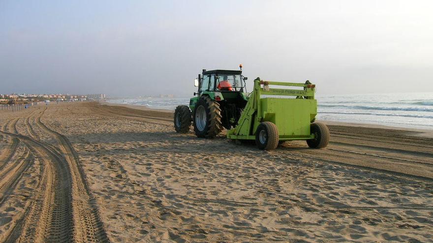 Un tractor, limpiando una playa.