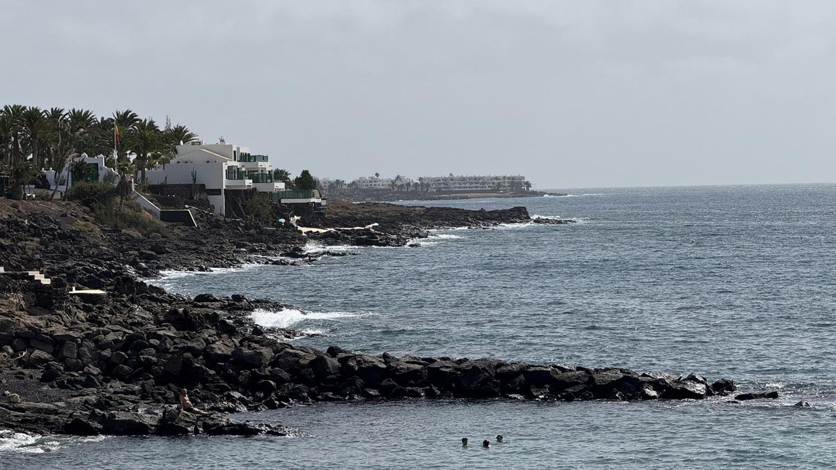 Tres bañistas, este jueves, en la playa de El Ancla, en Costa Teguise, a pocos metros de La Mareta.