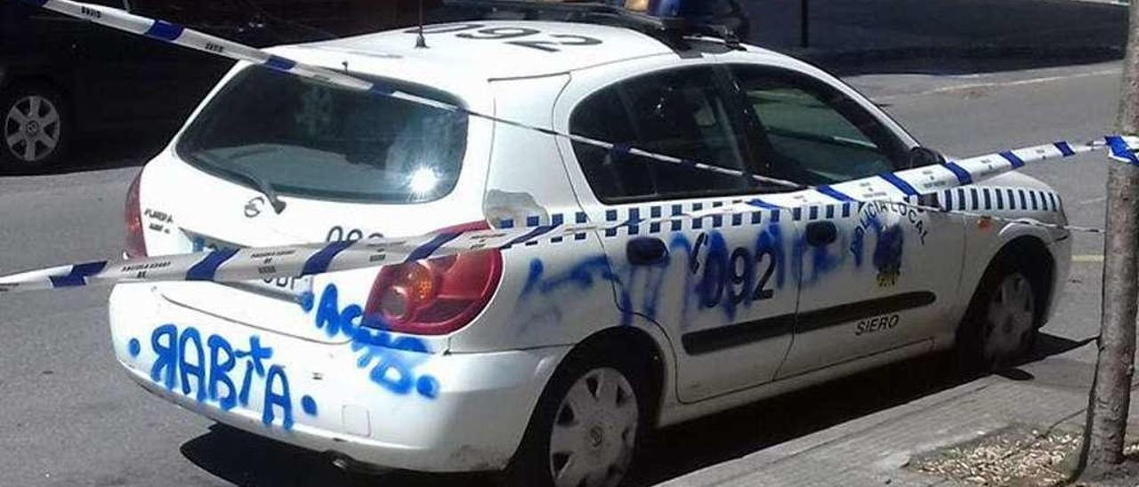 El coche de la Policía Local de Lugones, con las pintadas.