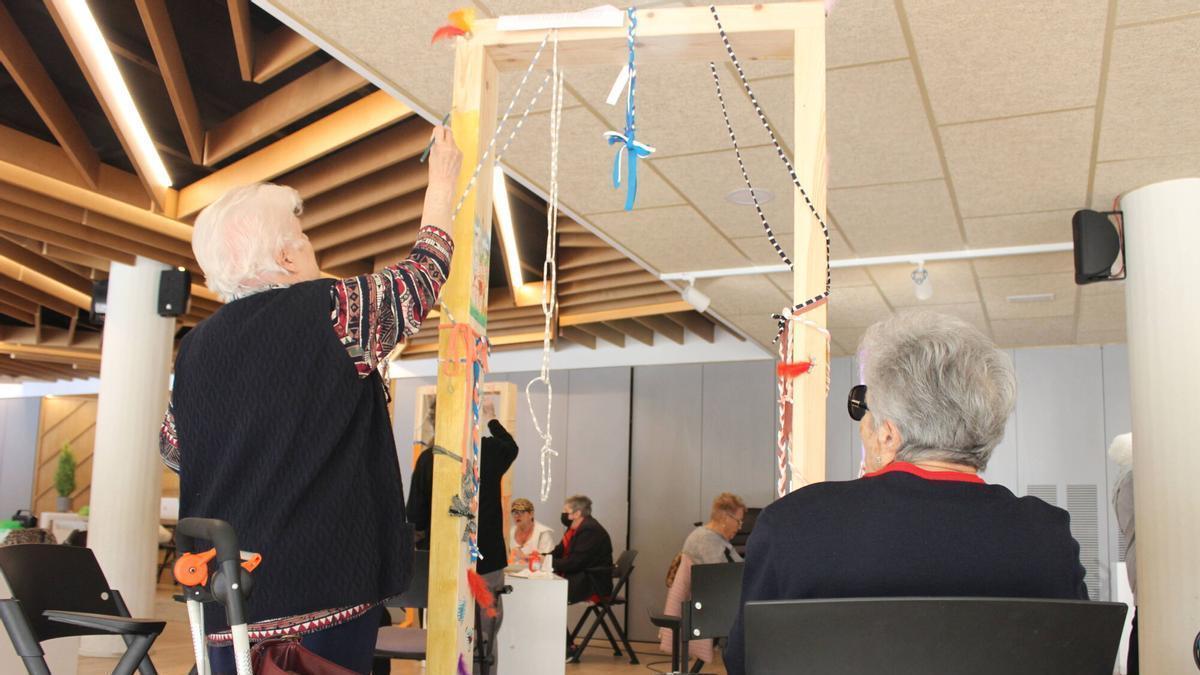 La Matilde Pérez i la Gloria Martínez decoren un dels llindars que sortirà al carrer per la Festa Major