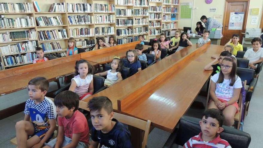 Los pequeños de San Cristóbal de Entreviñas, ayer, atentos a un cuenta cuentos en la biblioteca.