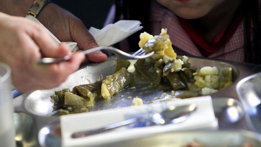 Una mujer da de comer a una niña.