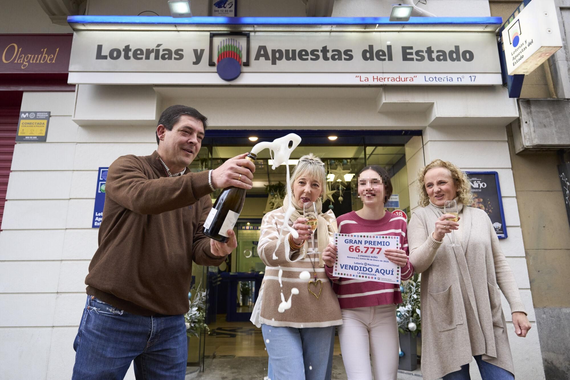 VITORIA (ESPAÑA), 06/01/2025.-Los responsables de la administración 17 'La herradura' de Vitoria celebrán la venta de treinta decimos del tercer premio de la loteria del Niño que se ha celebrado este lunes. EFE/ Adrian Ruiz Hierro