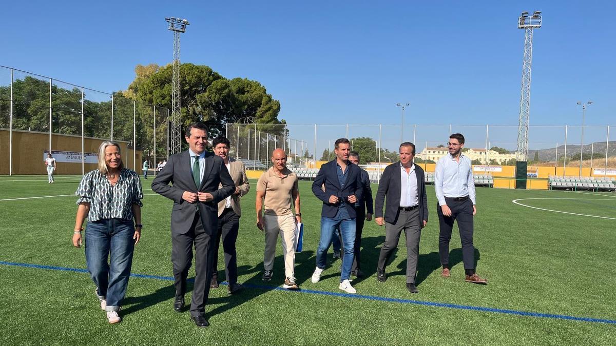 Isabel Albás y José María Bellido, junto a representantes de la federación, el club y la empresa adjudicataria en el campo de fútbol de El Naranjo.