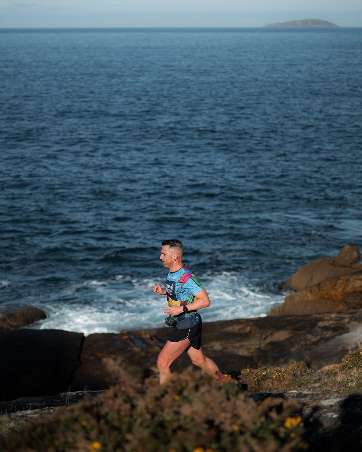 Uno de los participantes recorre el tramo de costa del Trail do Nocedo, en el litoral de Beluso.