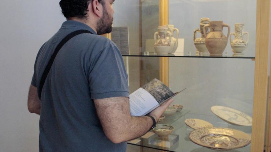 Un hombre observa una de las vitrinas colocadas de la muestra.