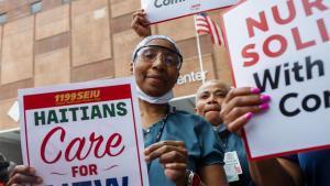 Los trabajadores sanitarios sostienen pancartas durante una manifestación de trabajadores sanitarios contra la expiración del Estatus de Protección Temporal (TPS) para los haitianos, celebrada en Nueva York el 5 de agosto de 2026. 