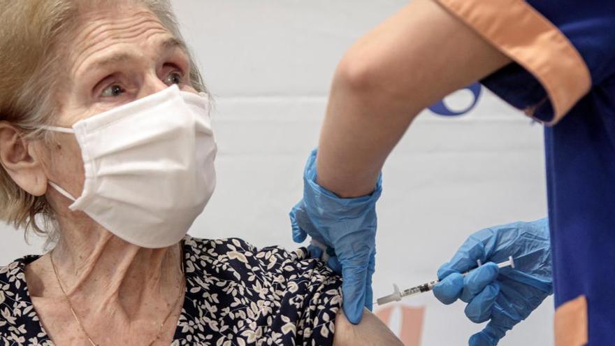 Un sanitario inyecta la vacuna a una mujer de una residencia de ancianos.