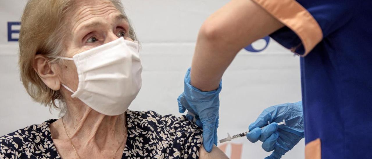 Un sanitario inyecta la vacuna a una mujer de una residencia de ancianos.