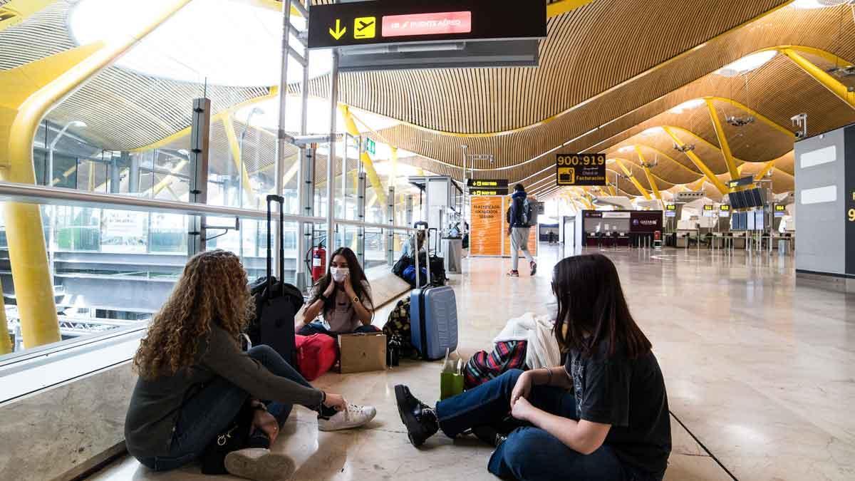 Jóvenes esperan su vuelo en el aeropuerto de Barajas.