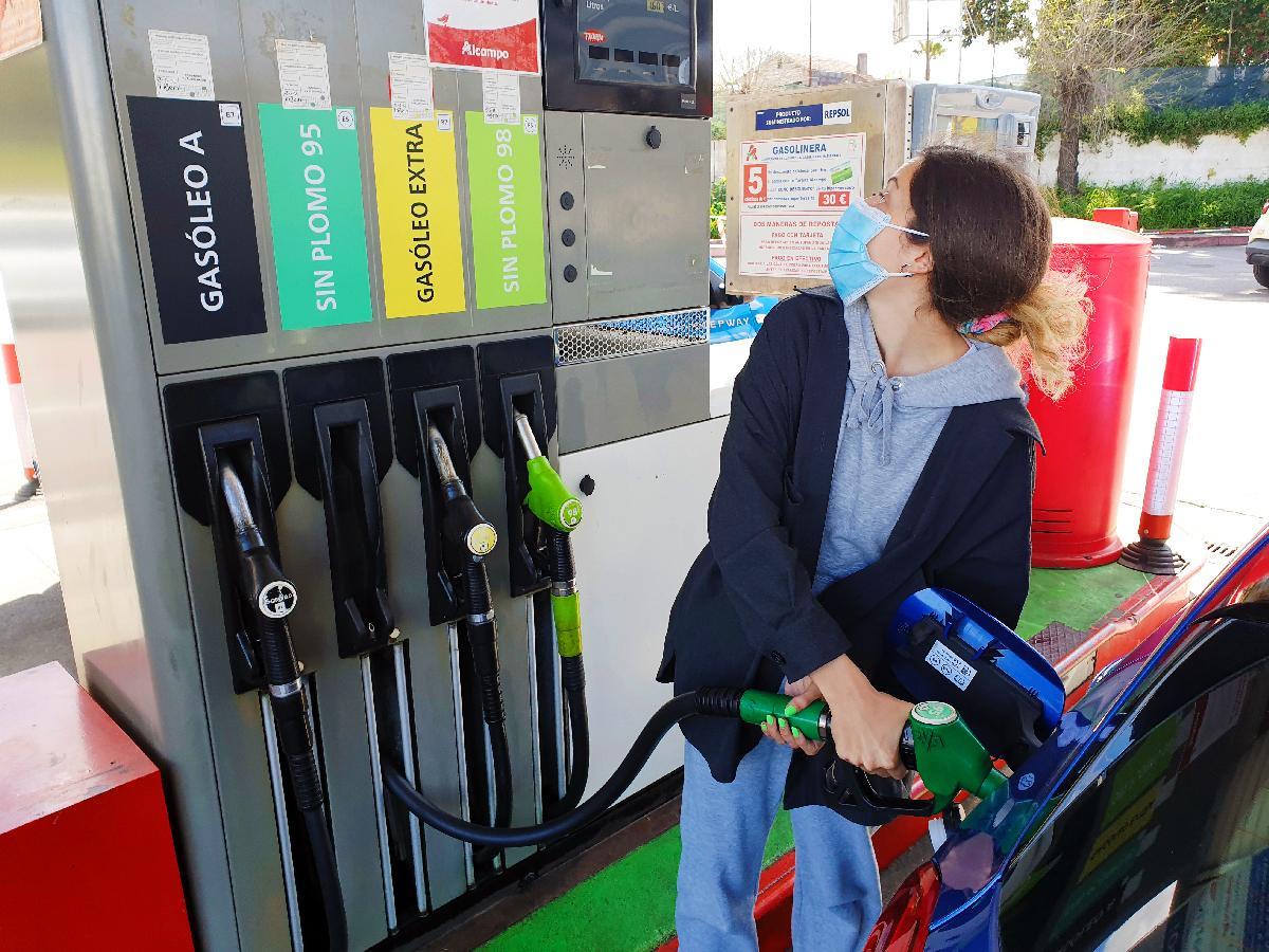 Una mujer reposta gasolina atenta al surtidor en Vigo.