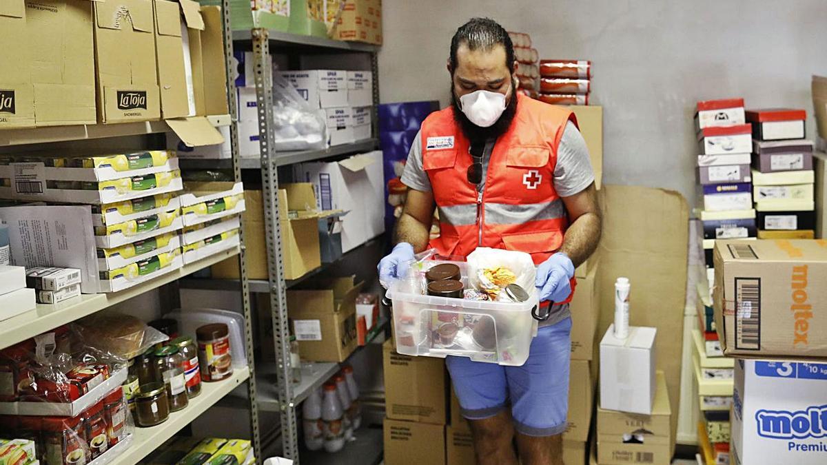 Un voluntari de la Creu Roja repartint menjar durant l’estat d’alarma en imatge d’arxiu. | ANIOL RESCLOSA