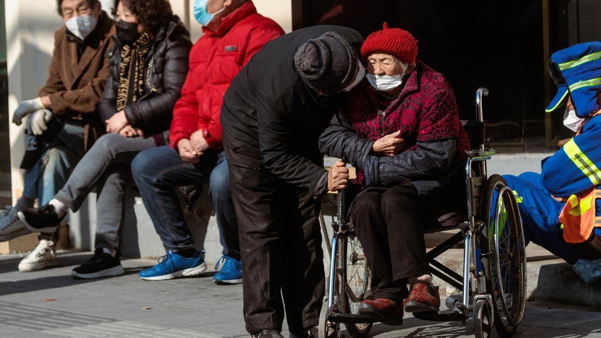 Ancianos toman el sol en una calle de Shangái, este martes.