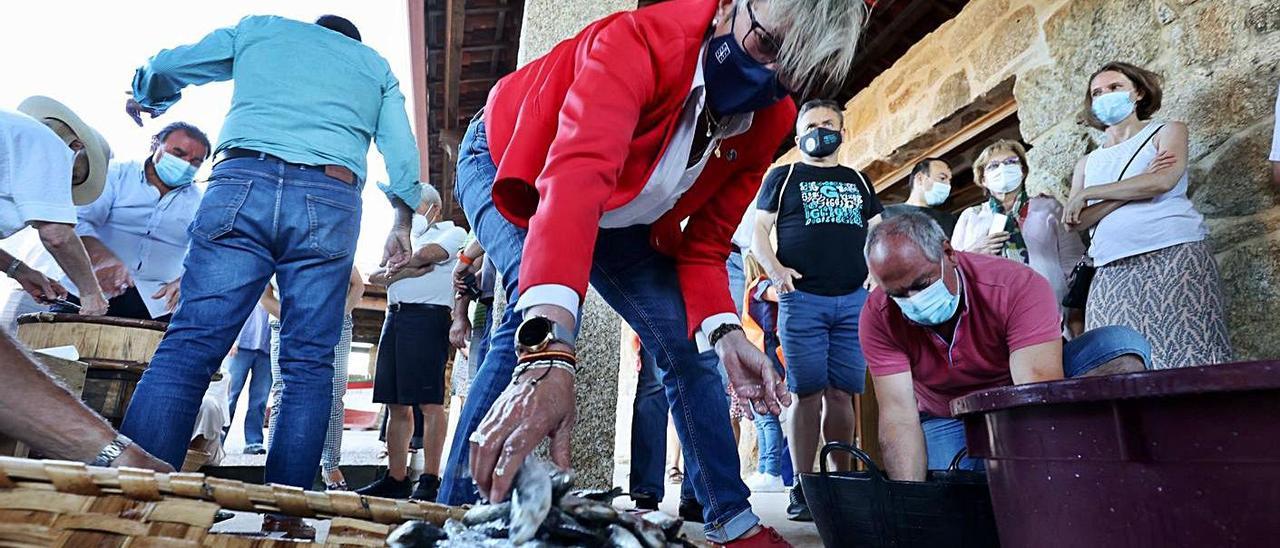 La conselleira do Mar, Rosa Quintana, participó ayer activamente en la tarea.  | // CEDIDA