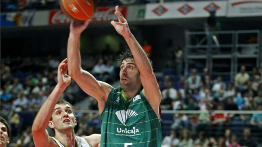 El escolta del Unicaja Málaga Berni Rodríguez (d) intenta superar la defensa del pívot esloveno del Real Madrid, Mirza Begic.