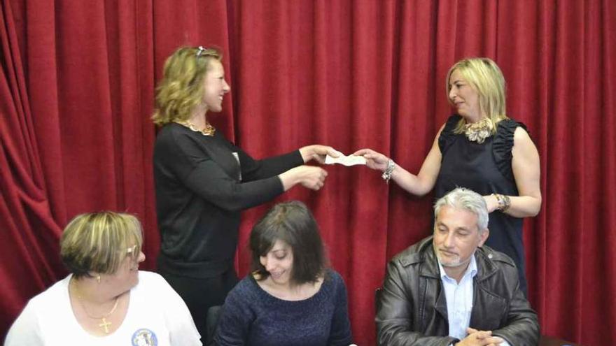 La concejal de Fiestas, Patricia Martín (derecha) entrega el cheque a la representante de una de las peñas.