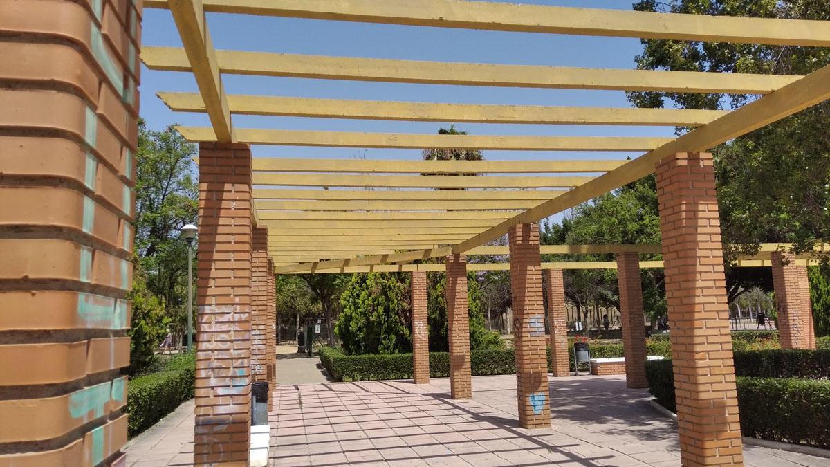 En lugar de fomentar la tranquilidad y el frescor gracias a una buena cubierta vegetal, las pérgolas instaladas en el Parque María Luisa, en la Carretera de Cádiz, promueven la insolación y también el vandalismo. Esta zona verde, cedida con posterioridad al Ayuntamiento, fue diseñada con una zona central de pérgolas sin tierra al pie de las columnas, algo imprescindible para que con los años estuviera cubierta de plantas y diera sombra. Ahora, el Consistorio ha decidido retirar las vigas porque a falta de otra cosa algunos las utilizan para recolgarse de ellas y hacer gimnasia.