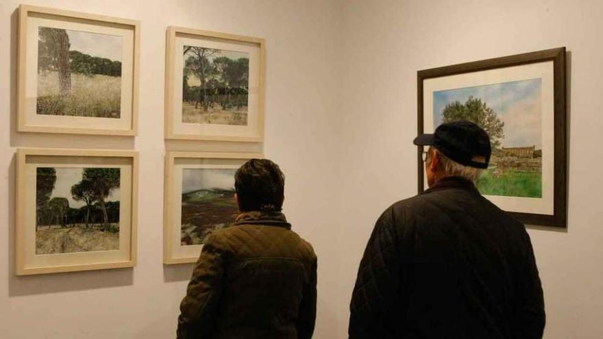 Dos visitantes ante los cuadros de Báez Mezquita en la inauguración.