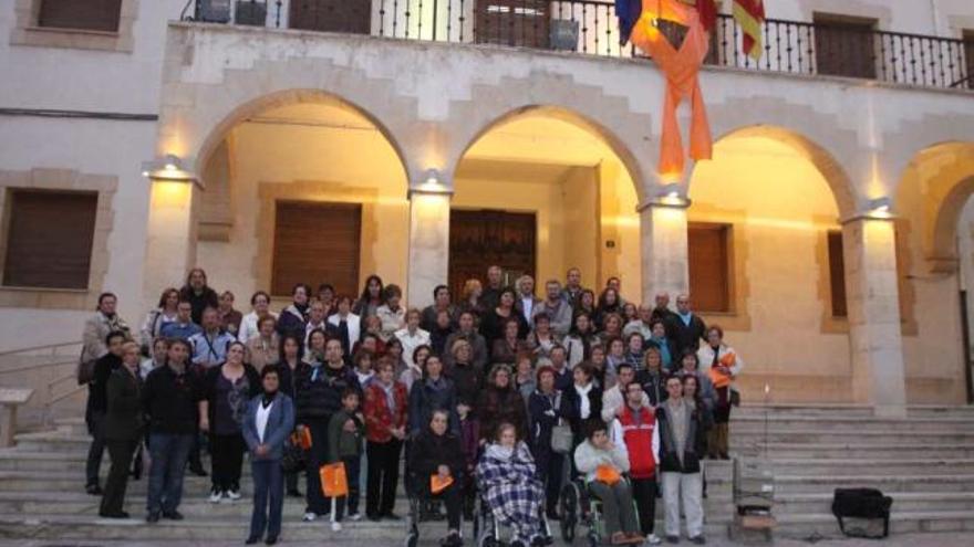 Los asistentes a la concentración de ayer posan con el lazo ya colgado en el Ayuntamiento.