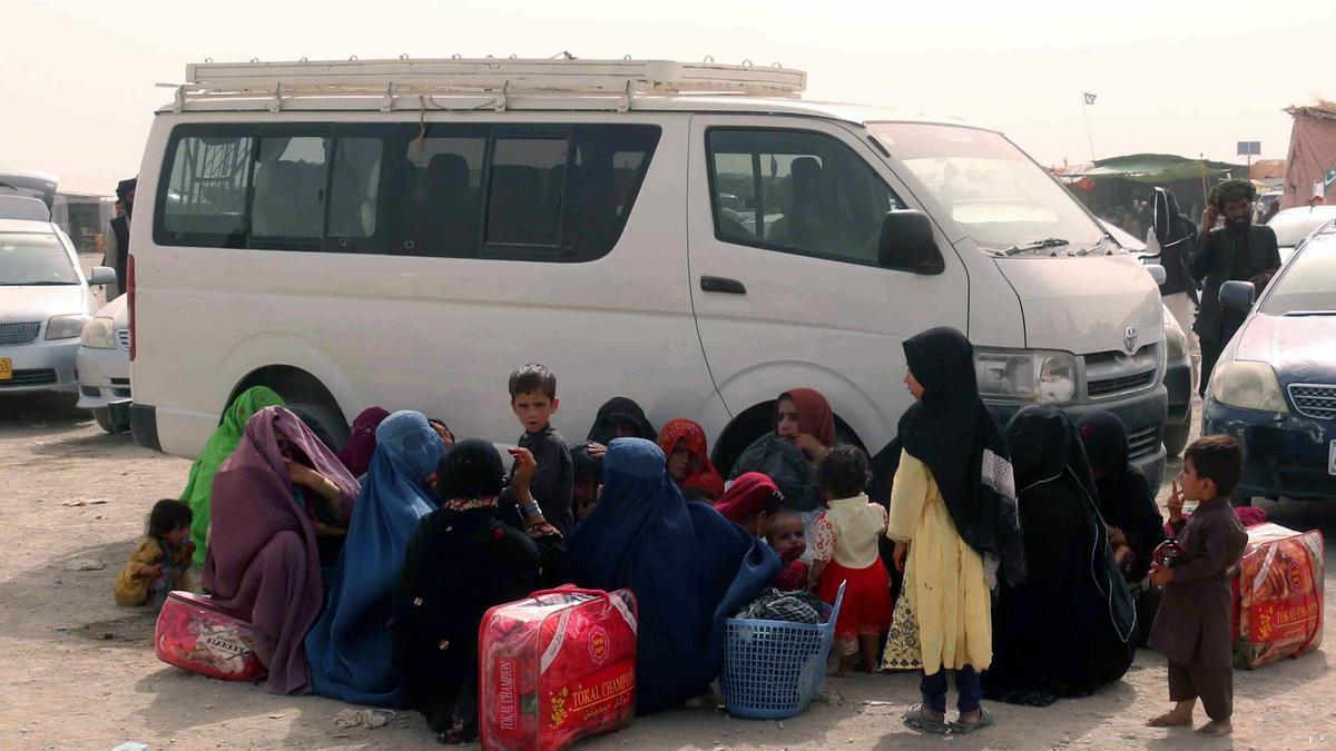 Una familia aguarda en un control fronterizo para poder huir de Afganistán.