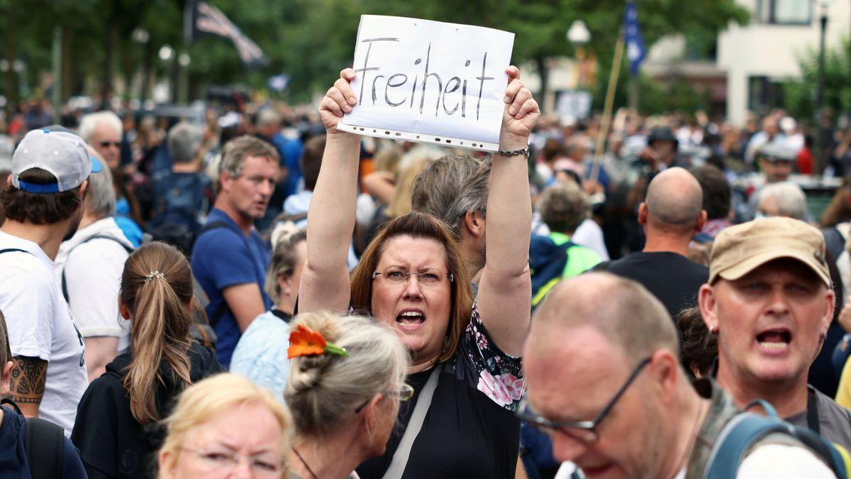 Una manifestante en Berlín protesta contra las restricciones y alza una pancarta que pone libertad.