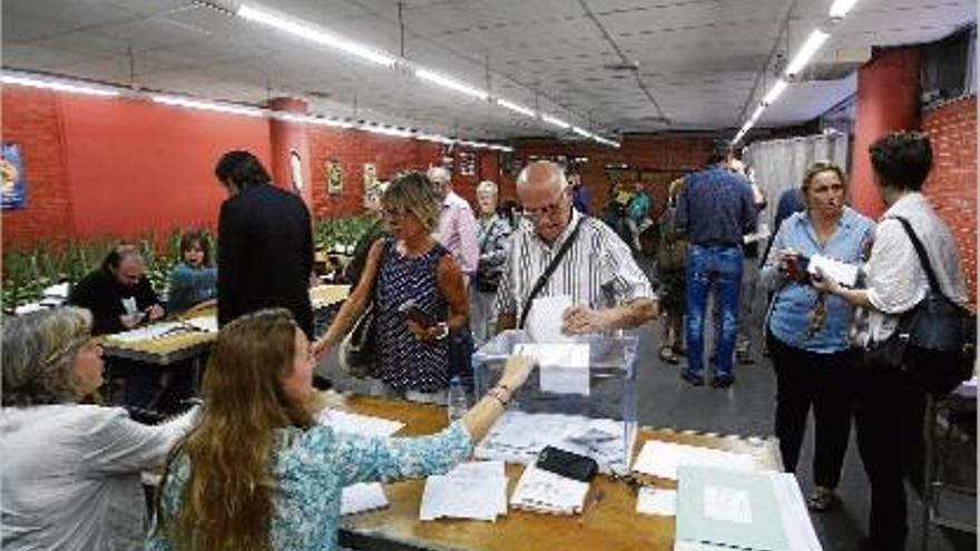 Un elector dipositant el seu vot en una urna del col·legi El Pla de Girona, ahir.