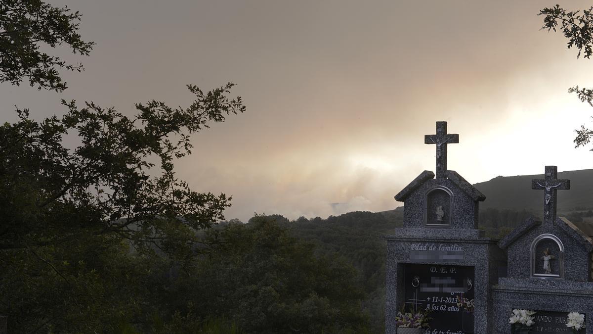 Vista de las llamas de un incendio desde un cementerio, en Laza (Ourense)