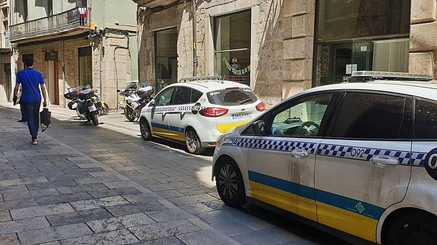 Cotxes i motocicletes de la policia a l&#039;entrada del carrer on hi ha els ocupes.