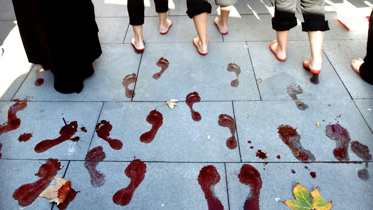 Unas mujeres dejan las huellas de sus pies teñidos de rojo durante la manifestación celebrada en Sevilla y convocada por la Plataforma 8 de Marzo con motivo del Día Internacional contra la Violencia hacia las Mujeres.