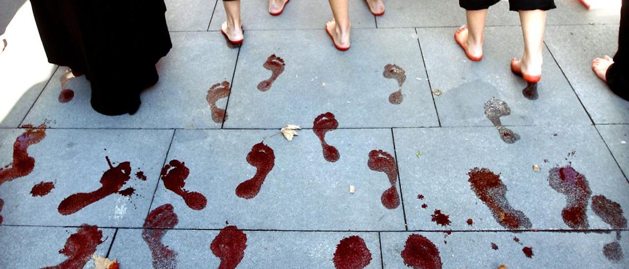 Unas mujeres dejan las huellas de sus pies teñidos de rojo durante una manifestación convocada por la Plataforma 8 de Marzo.
