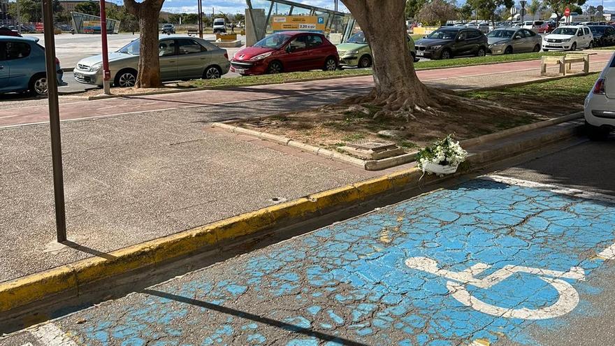 Flores en las plazas de aparcamiento de Alzira en memoria del discapacitado fallecido