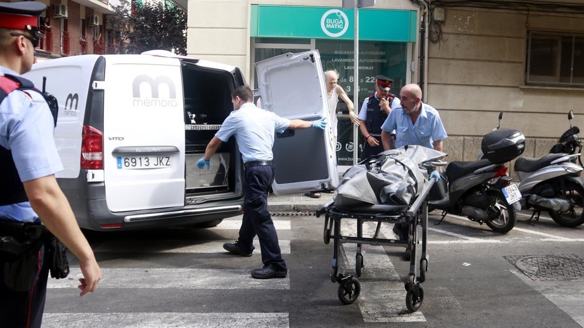 Servicios funerarios retiran el cuerpo de la mujer muerta en la calle Escultor Canet de Sants.