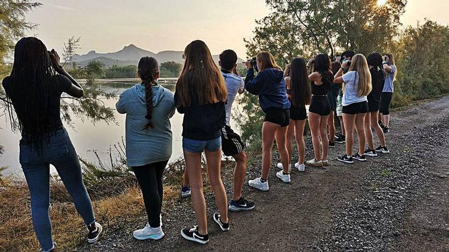 Un grupo de jóvenes observa con prismáticos en parque natural.