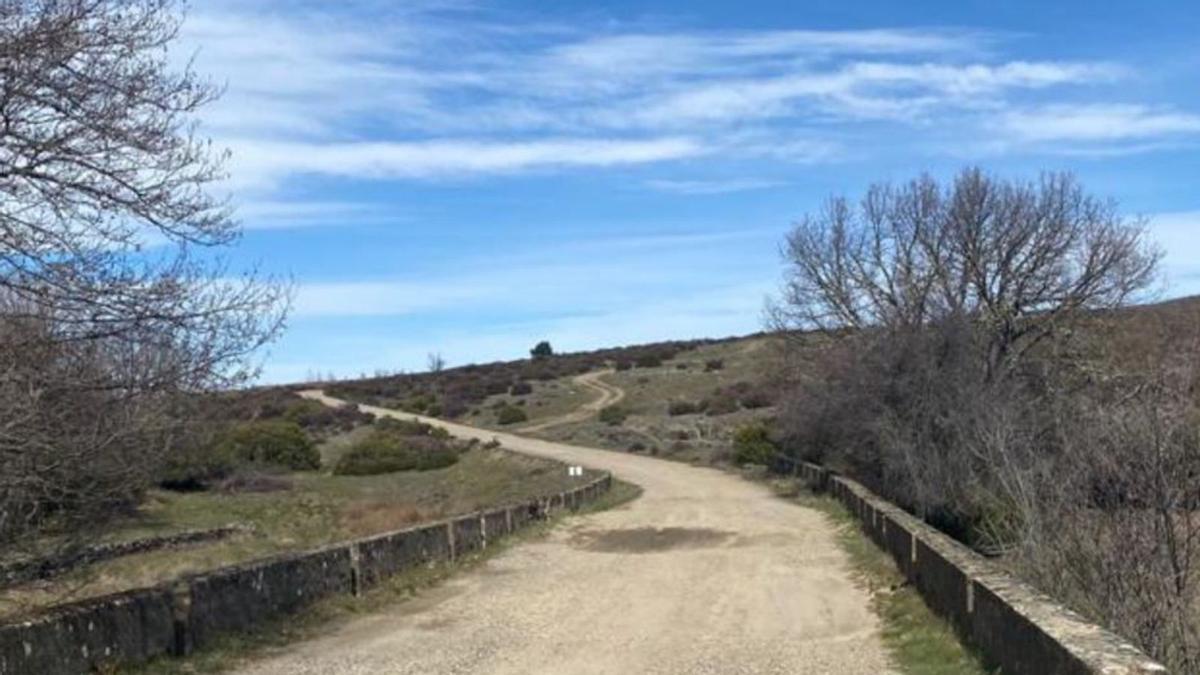 A la izquierda, los vecinos de Villarino de Manzanas, en el punto de inicio del Camino del Lobo, tras reunirse en concejo. Sobre estas líneas, un tramo del Camino del Lobo. | Chany Sebastián