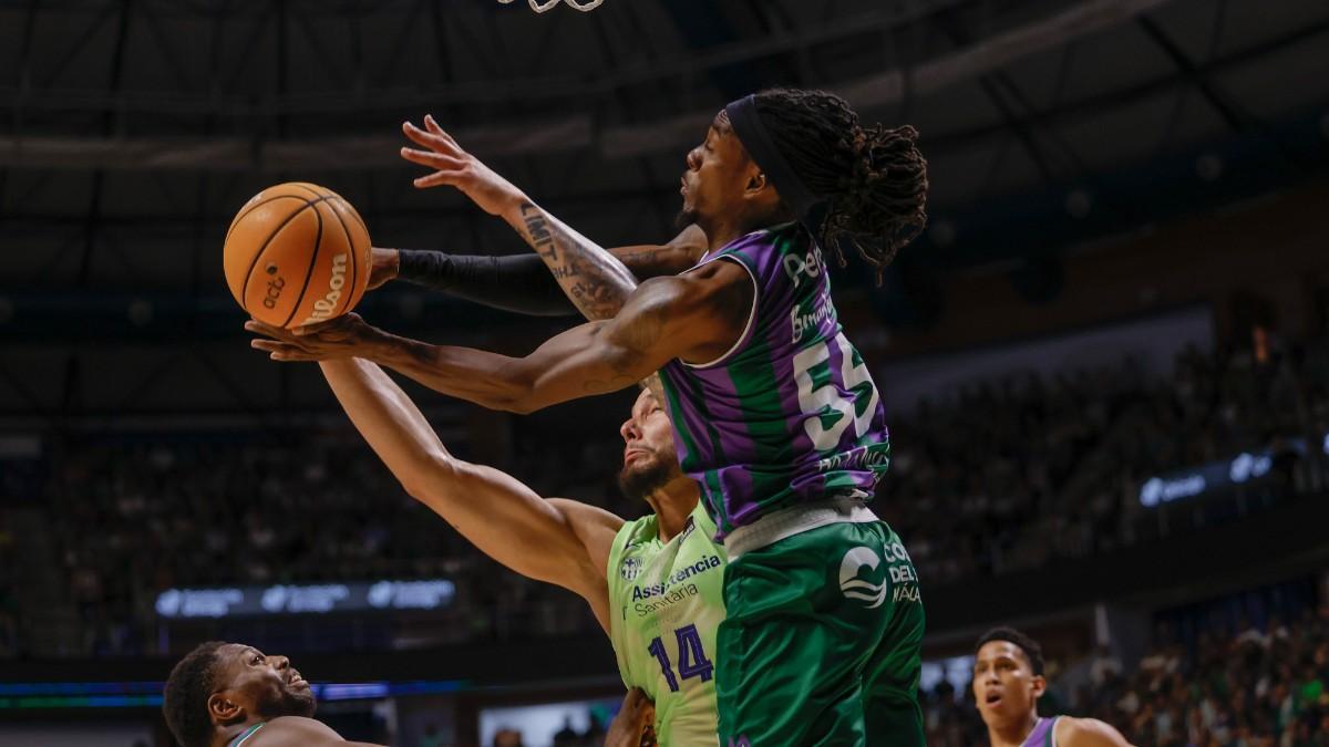 El pívot del Barcelona Willy Hernangómez (c) pelea un balón con Hendrick Perry, de Unicaja, durante el partido de los cuartos de final de la Liga Endesa de baloncesto que Unicaja y FC Barcelona disputan este martes en Málaga
