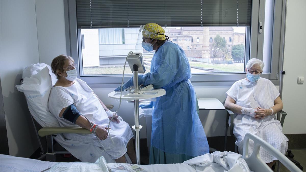 Barcelona 18 12 2020  Reportaje en el Hospital de Sant Pau   Planta hospitalarias con enfermos de coronavirus covid-19 En la foto  las pacientes Ramona Vazquez (izda ) y Angeles Navarro (dcha)   ambas con covid   atendidas por la enfermera Montse Foto de Ferran Nadeu