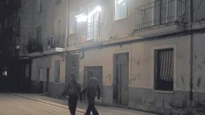 Las luces de una vivienda iluminan una calle de Paiporta sin luz.