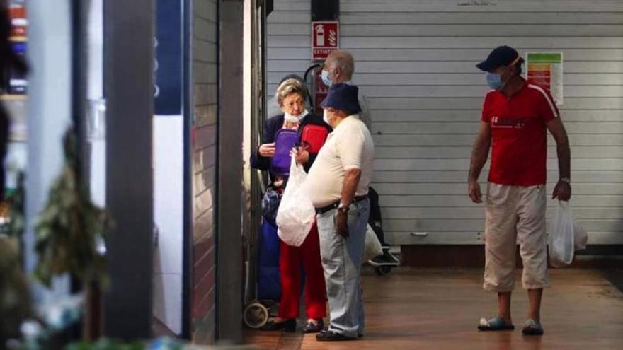 Varias personas compran este jueves en el mercado de El Palo.