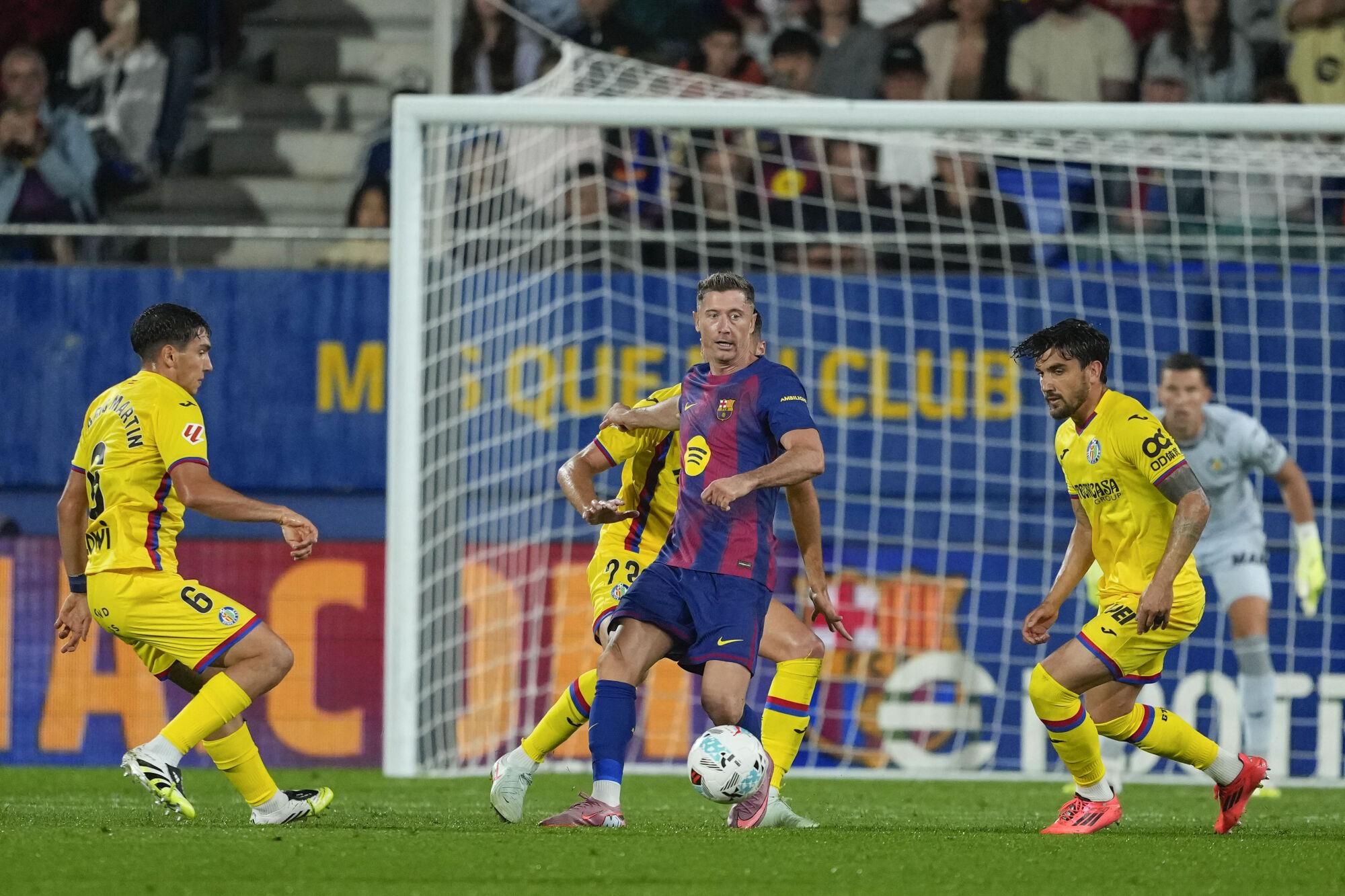 El delantero del Barcelona Robert Lewandowski (c) controla el balón entre los jugadores del Getafe, durante el partido de la jornada 5 de LaLiga que FC Barcelona y Getafe CF disputaron en el Estadi Johan Cruyff. EFE/Alejandro García. (Getafe)