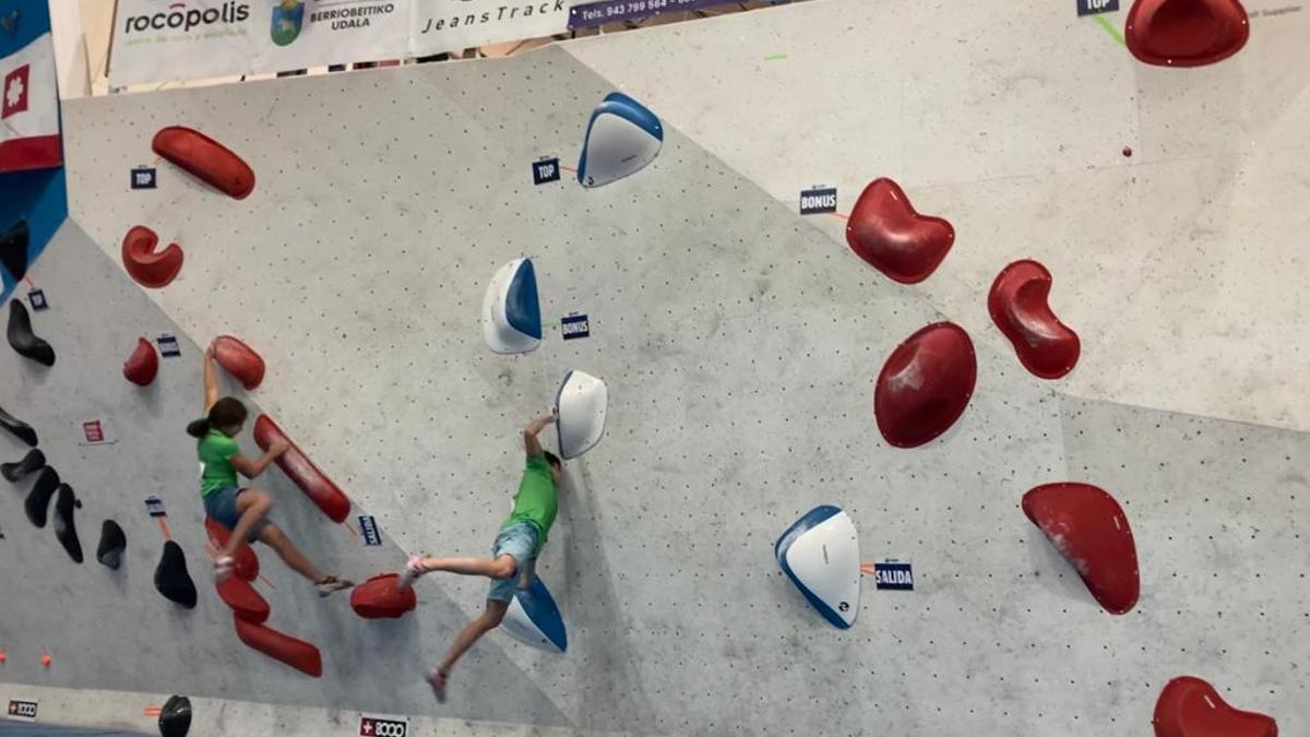 Dos participantes escalan en un momento durante la competición de bloque.